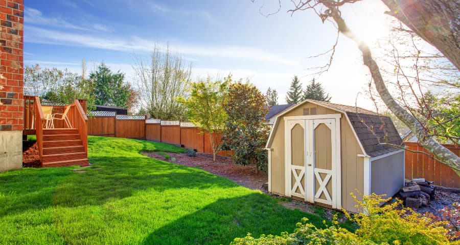 Fenced backyard with storage shed in Spokane